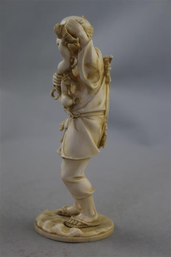 A Japanese ivory figure of a farmer, Meiji period, 16.5cm